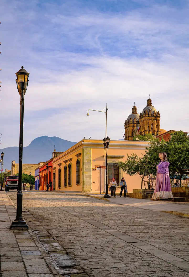 Calle empedrada de un municipio con templo al fondo